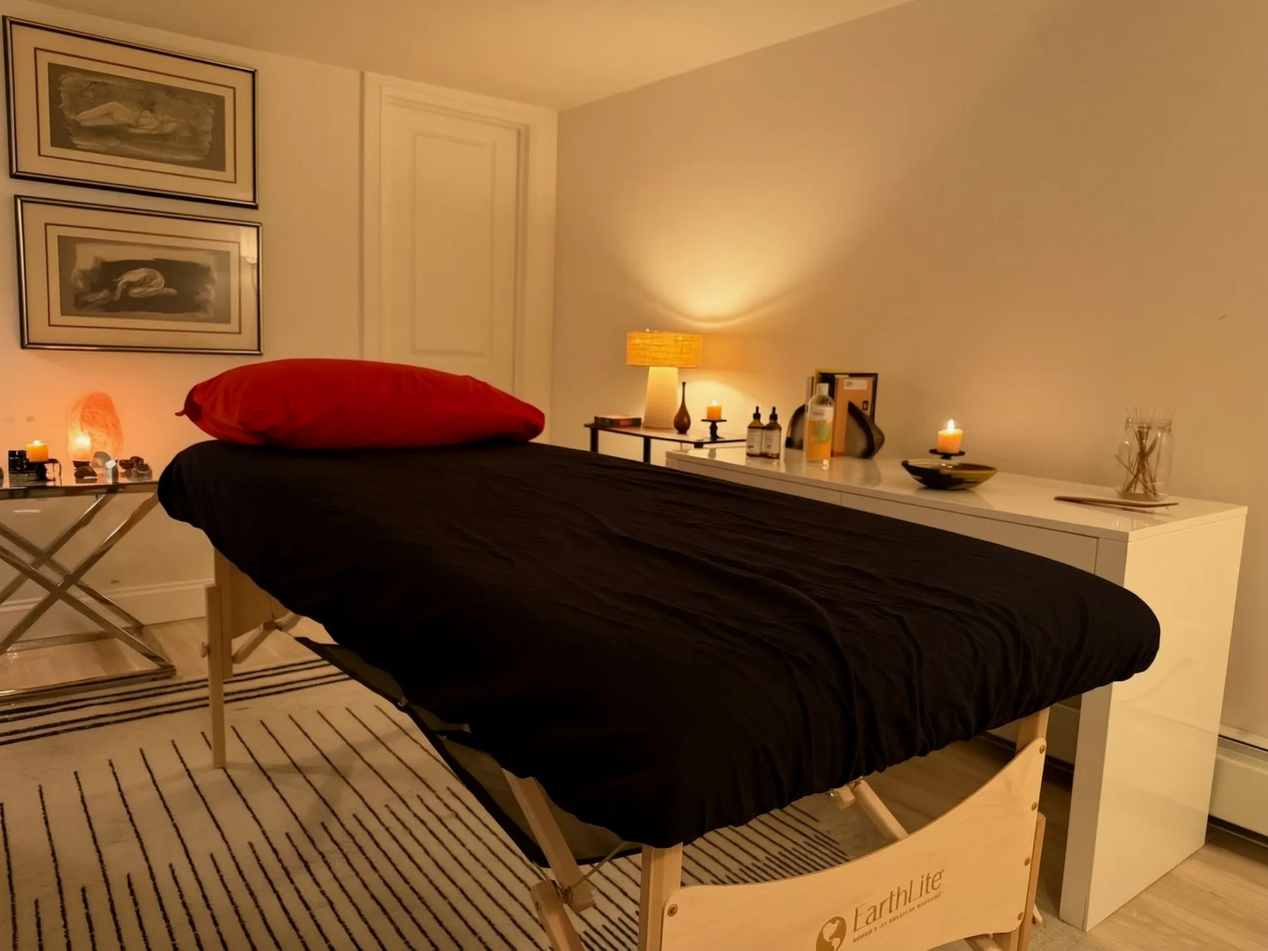 Max's massage studio in Woodside, Queens — heated massage table dressed in black and red, candlelight and warm lamps